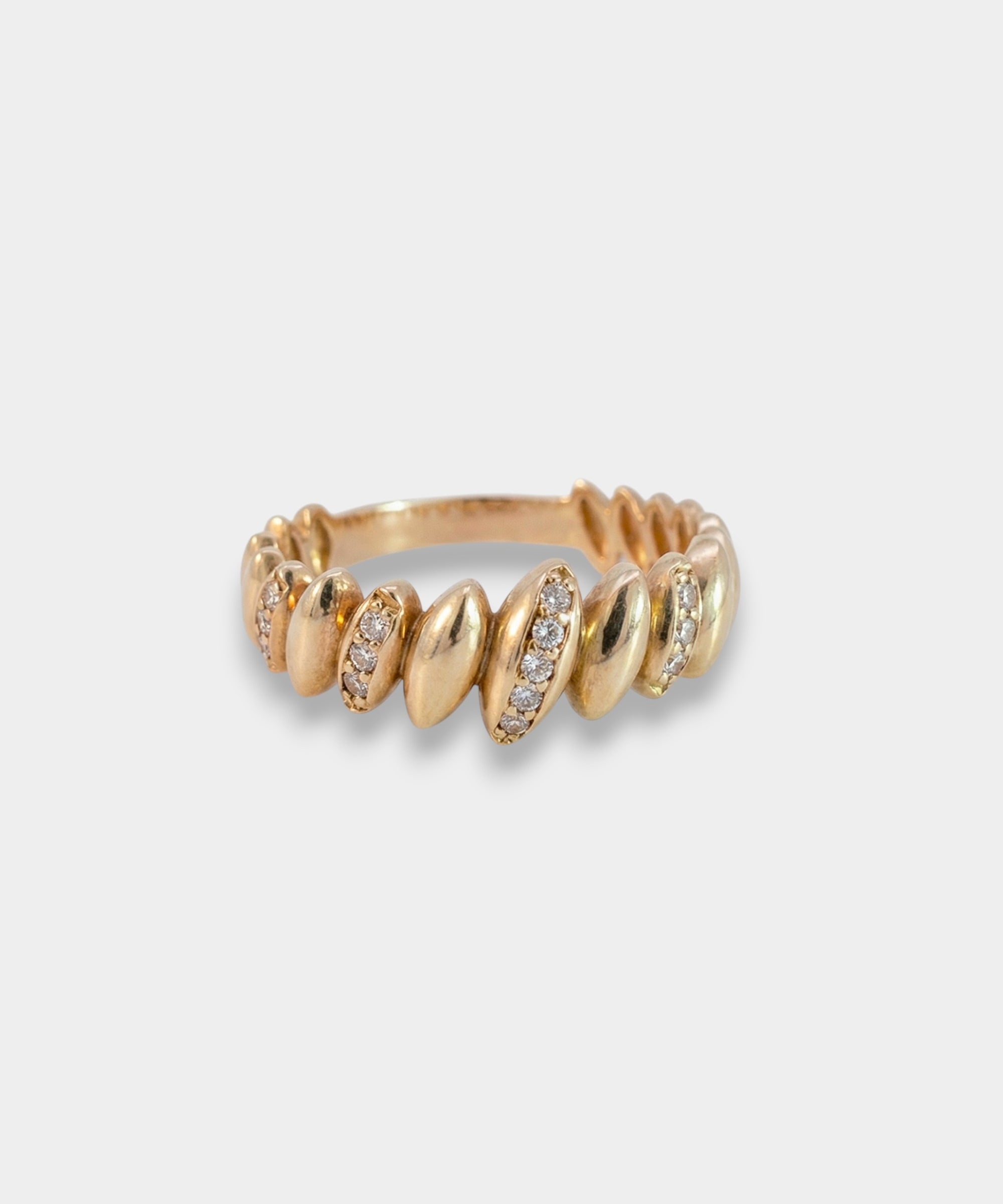Gold ring with embedded stones on a light gray background