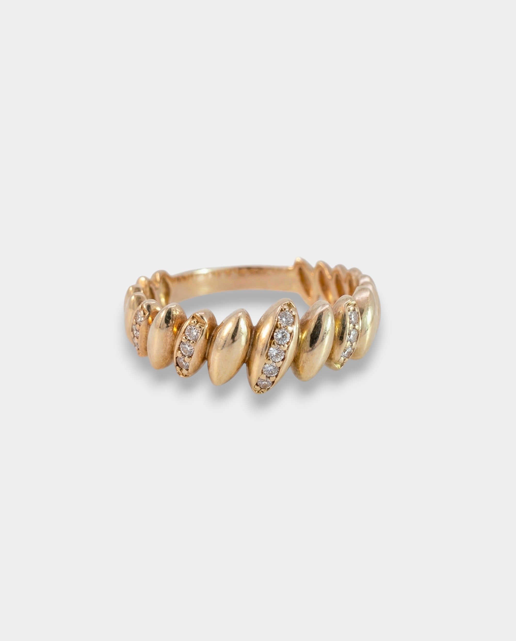 Gold ring with embedded stones on a light gray background