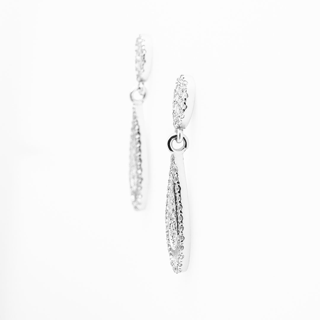 Pair of white gold hoop earrings on a white background