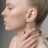 Woman wearing a diamond earring with a neutral background
