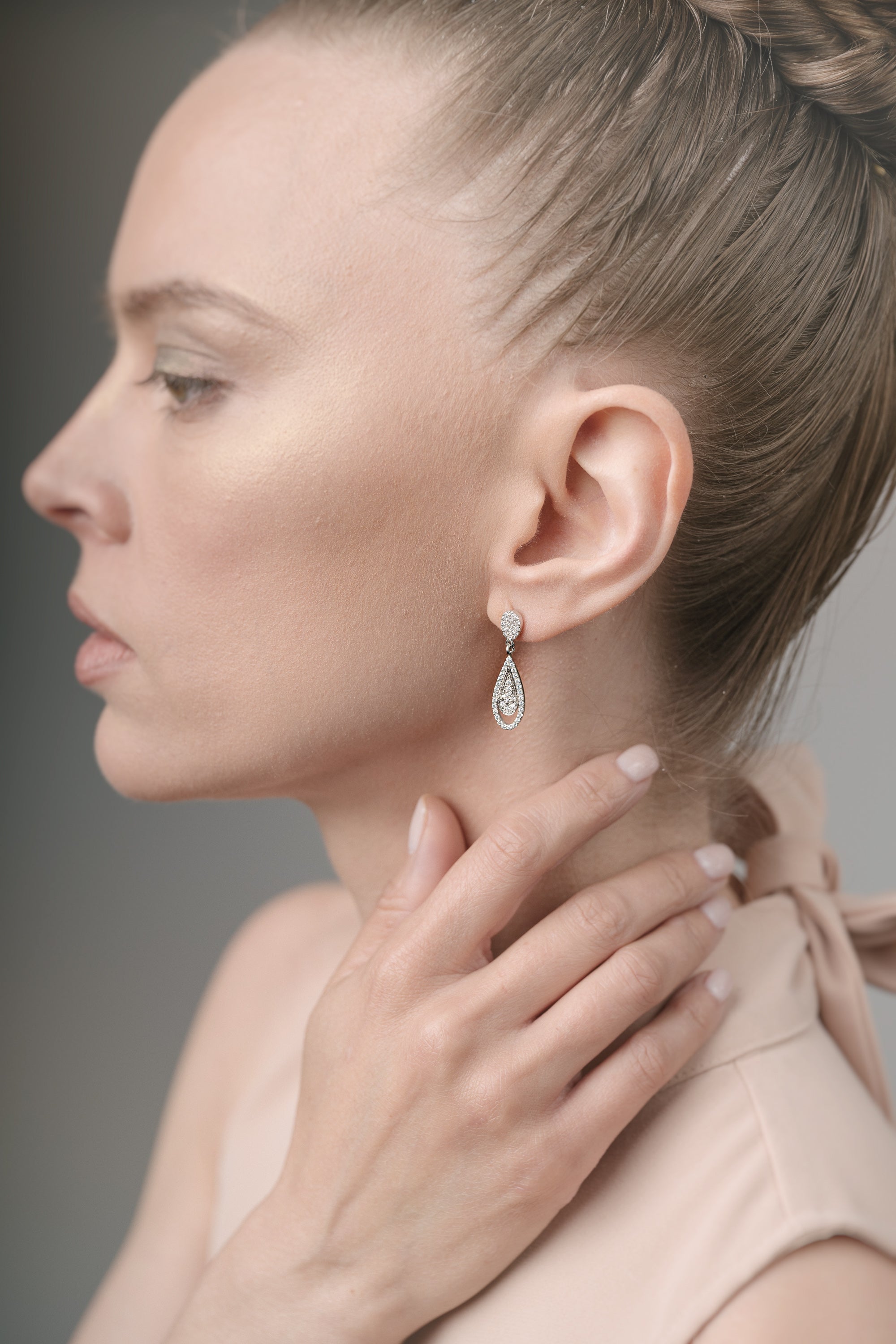 Woman wearing a diamond earring with a neutral background