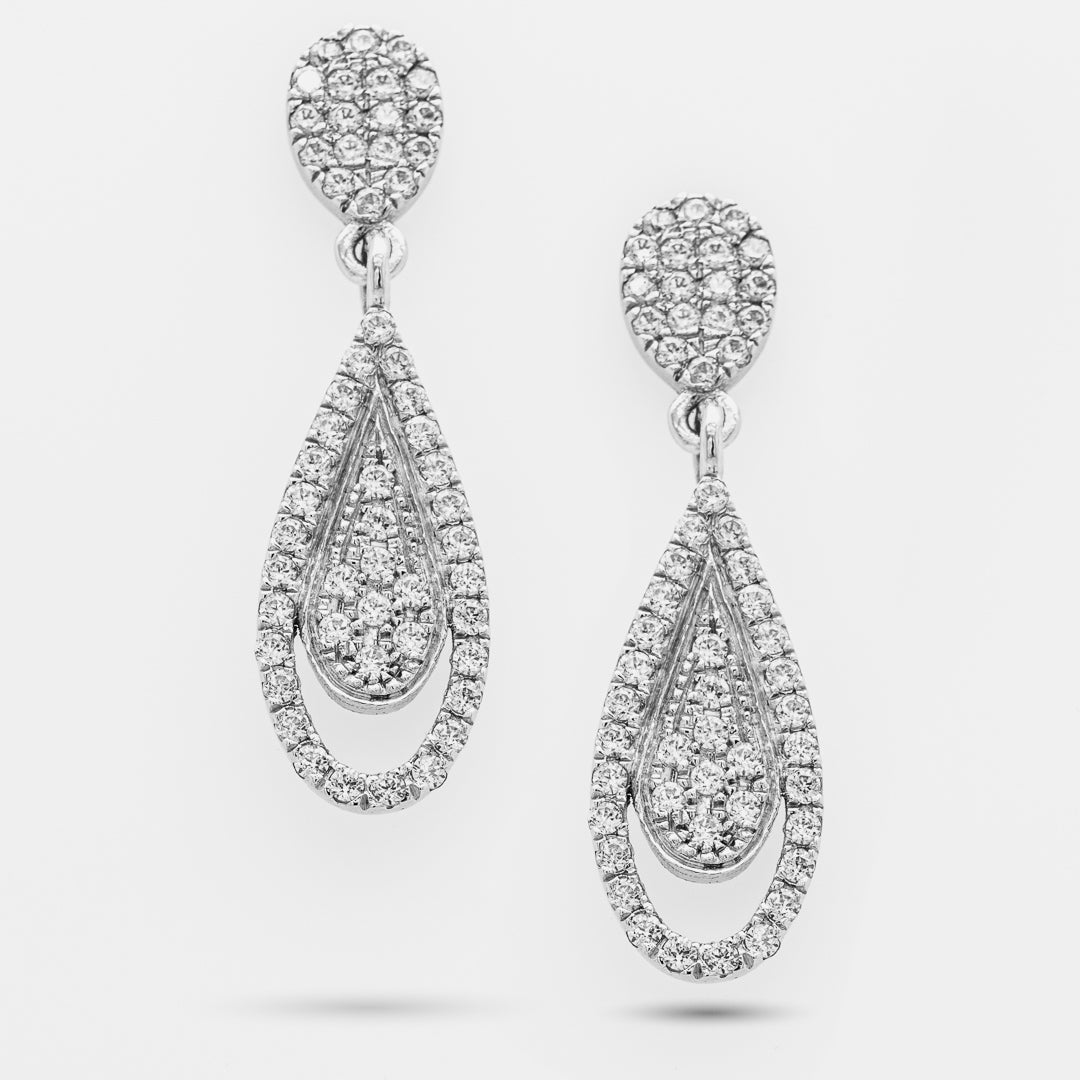 Pair of teardrop-shaped white gold earrings with clear gemstones on a white background