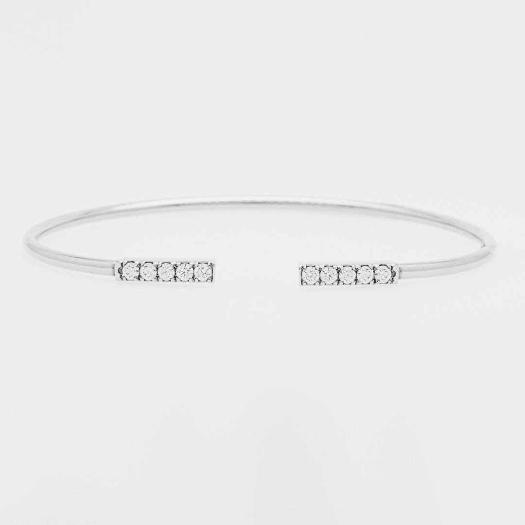 White gold bangle with small zircons on a light gray background