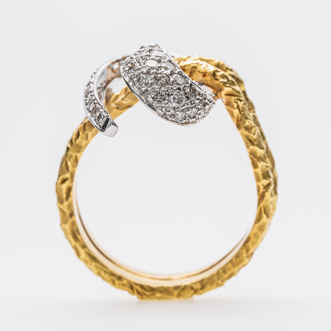 Gold ring with textured band and diamond-encrusted design on a white background