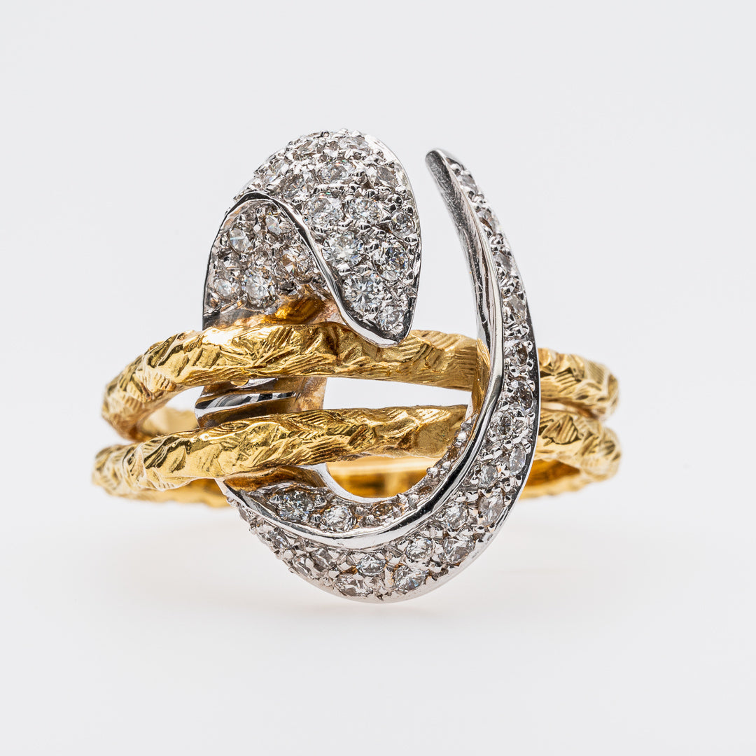 Yellow gold and white gold snake-shaped ring with diamond accents on a white background