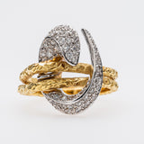 Yellow gold and white gold snake-shaped ring with diamond accents on a white background