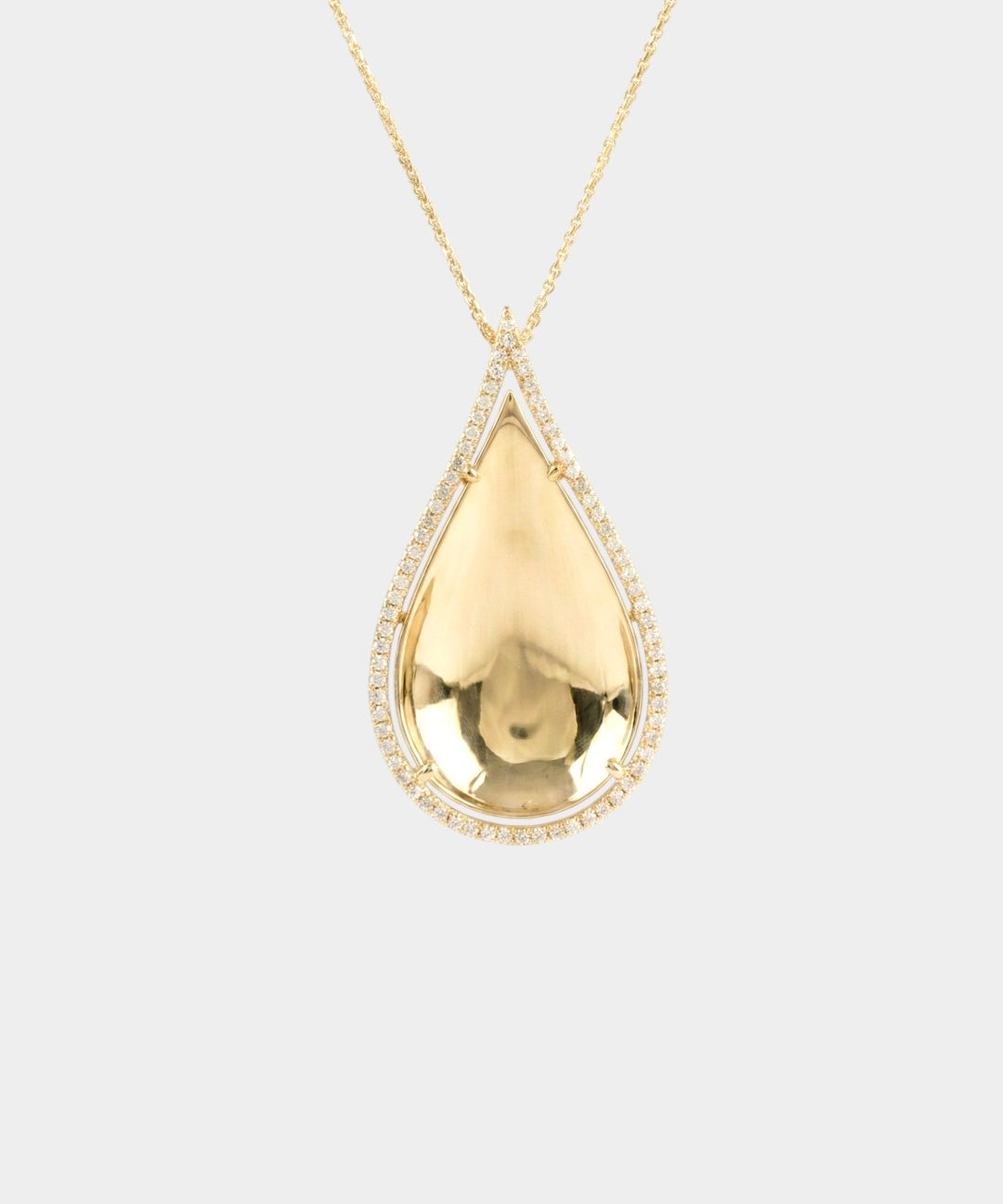 Gold teardrop pendant necklace on a light gray background