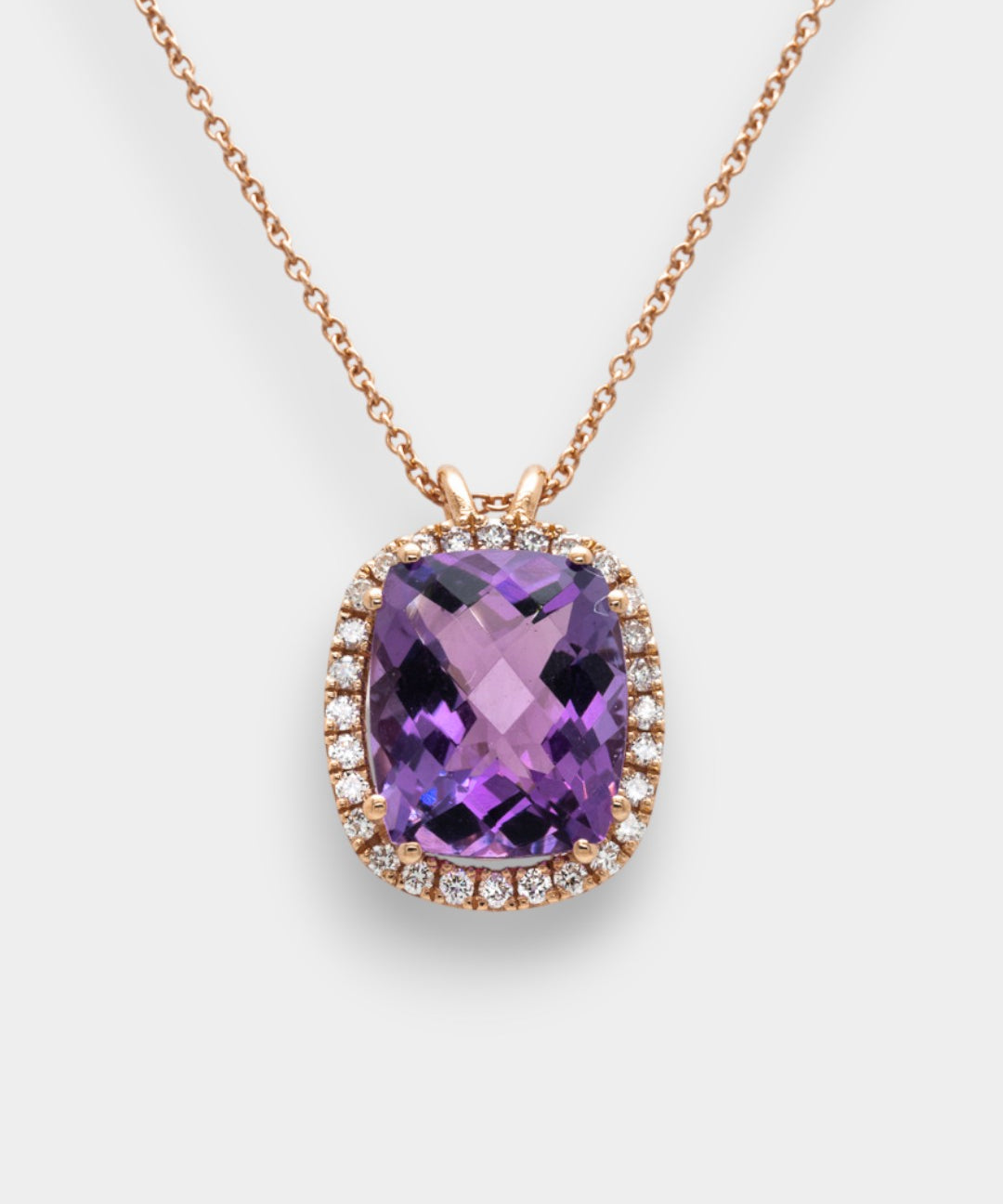 Purple amethyst necklace with rose gold chain on a white background