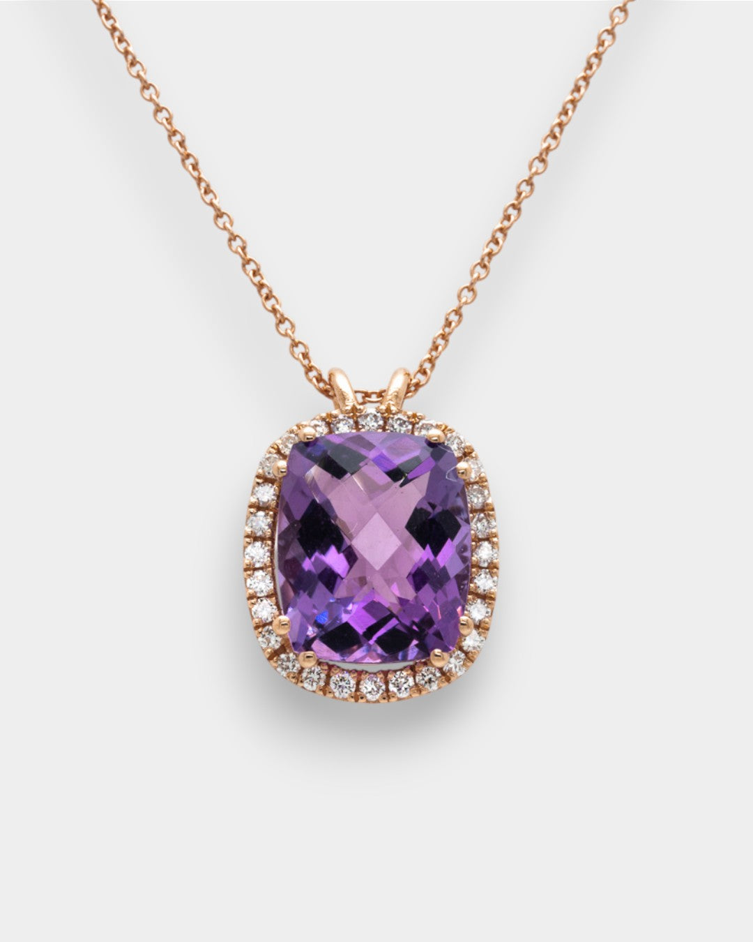 Purple amethyst necklace with rose gold chain on a white background