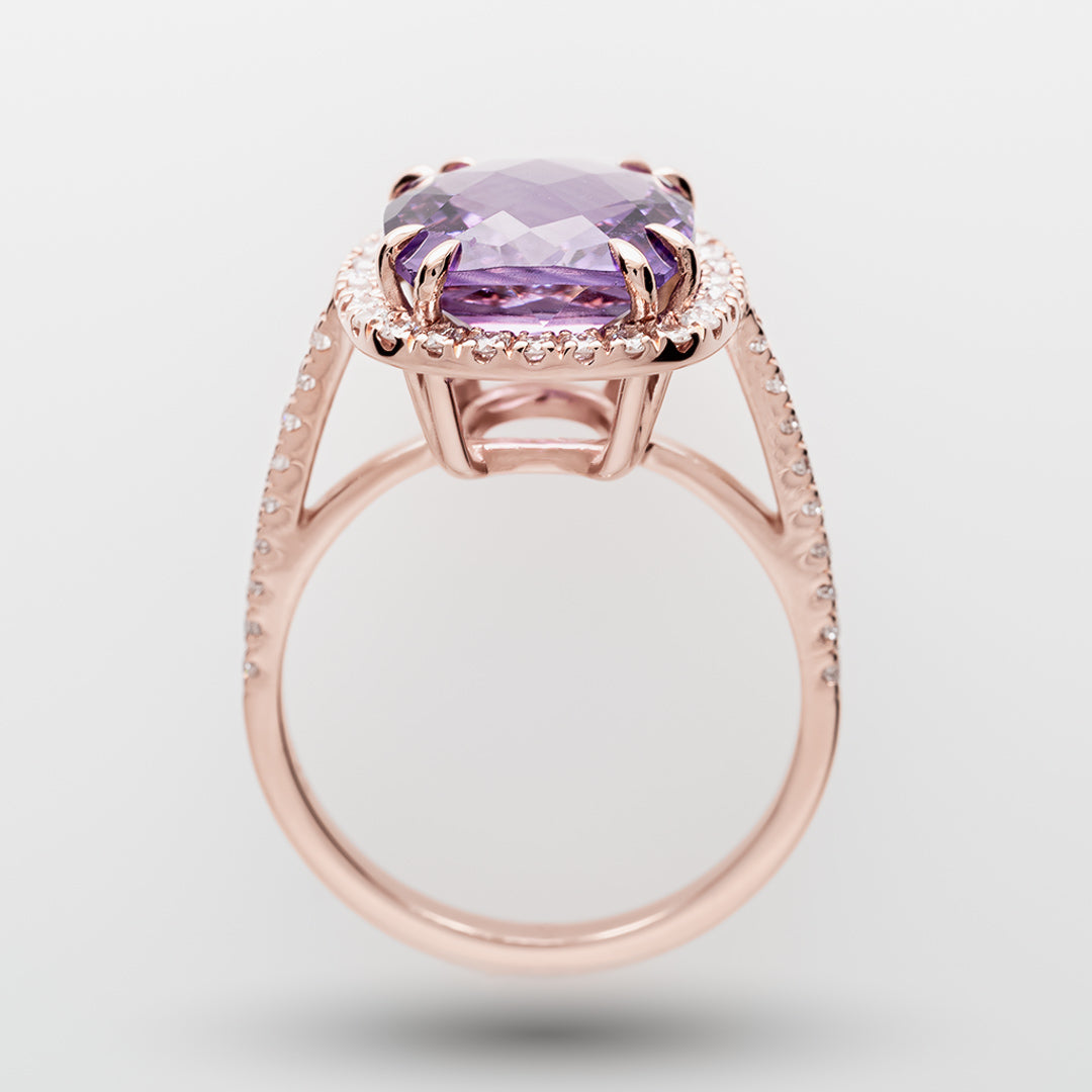 Rose gold ring with a purple amethyst on a light gray background