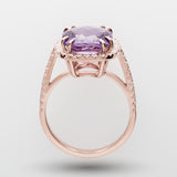 Rose gold ring with a purple amethyst on a light gray background