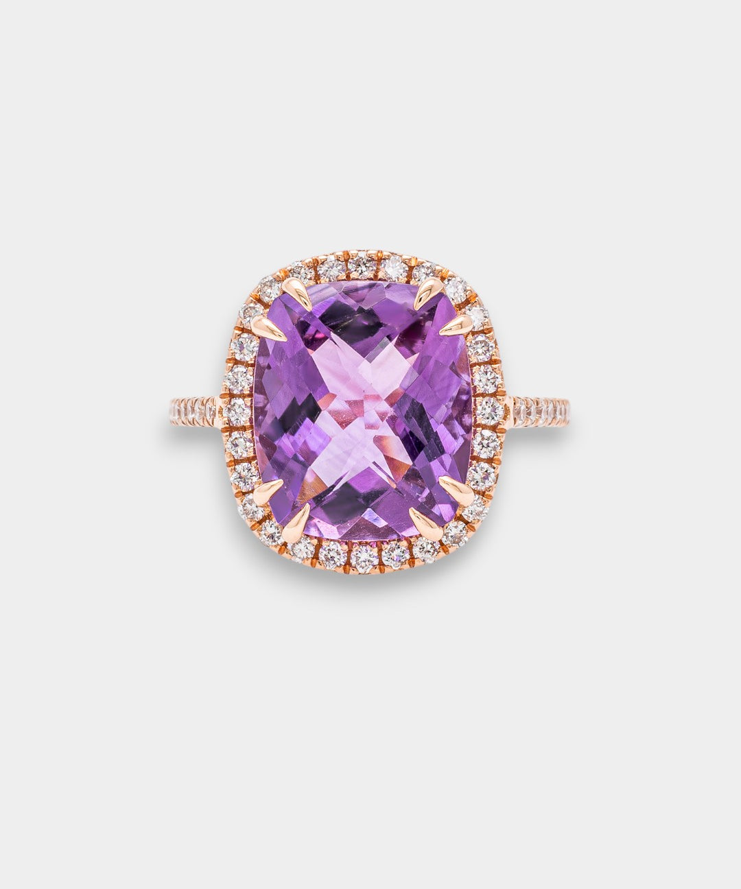 Ring with a purple amethyst and rose gold band on a light gray background