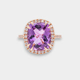 Ring with a purple amethyst and rose gold band on a light gray background
