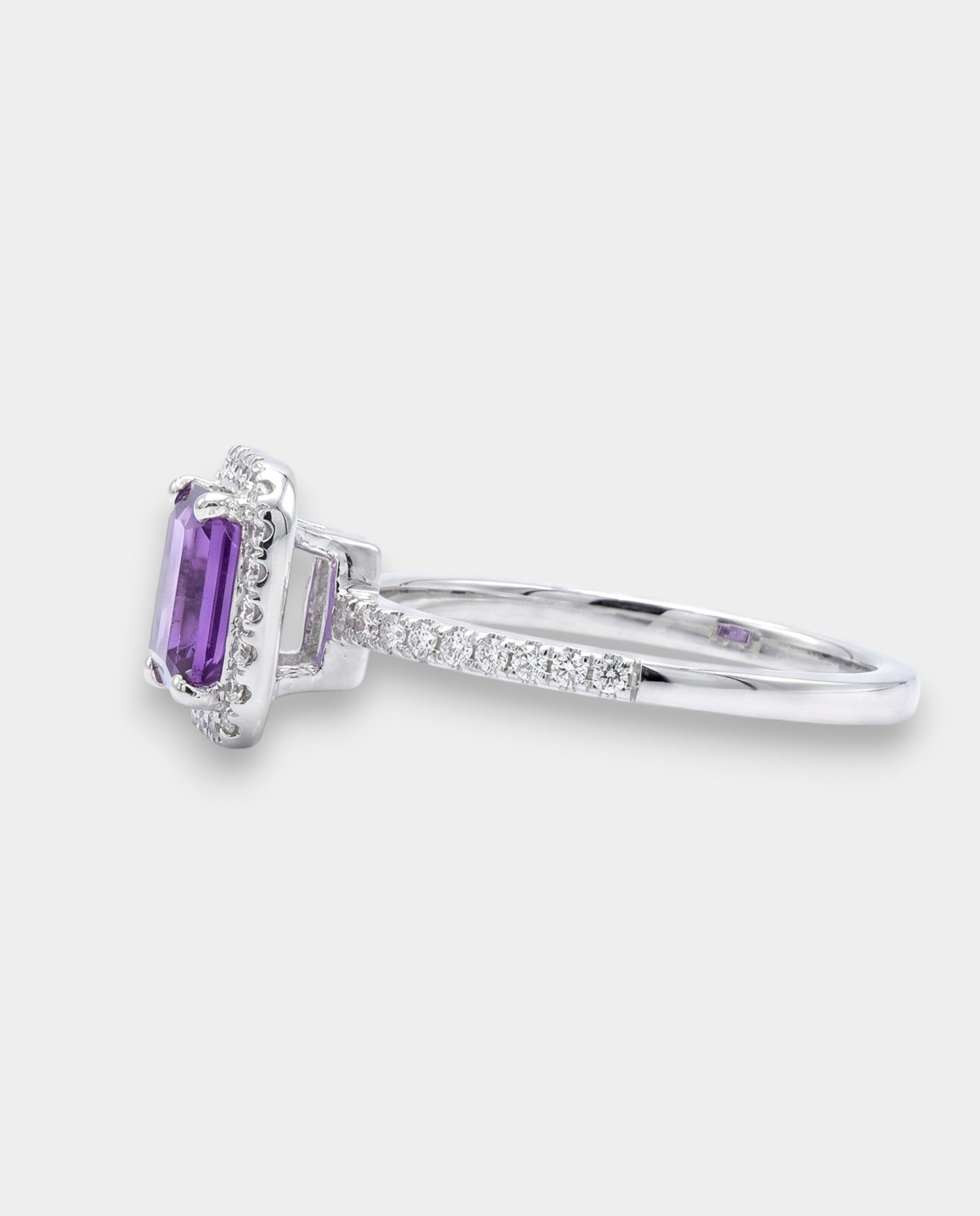 Ring with a purple amethyst and diamond accents on a white background side view