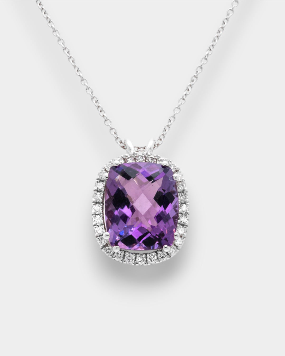 Purple amethyst necklace with diamond halo on a white background