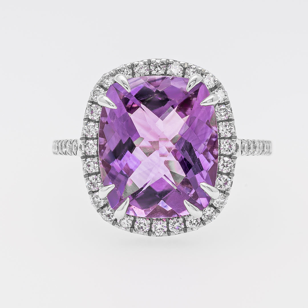 Ring with a purple amethyst and diamond-studded halo on a light gray background