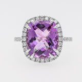 Ring with a purple amethyst and diamond-studded halo on a light gray background