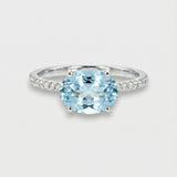 Ring with a oval-cut blue aquamarine on a light gray background