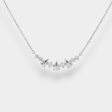 White gold necklace with small teardrop pendents and diamonds on a light gray background