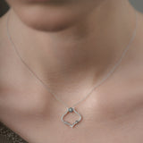 Necklace with a pendant worn by a person, focusing on the jewelry.