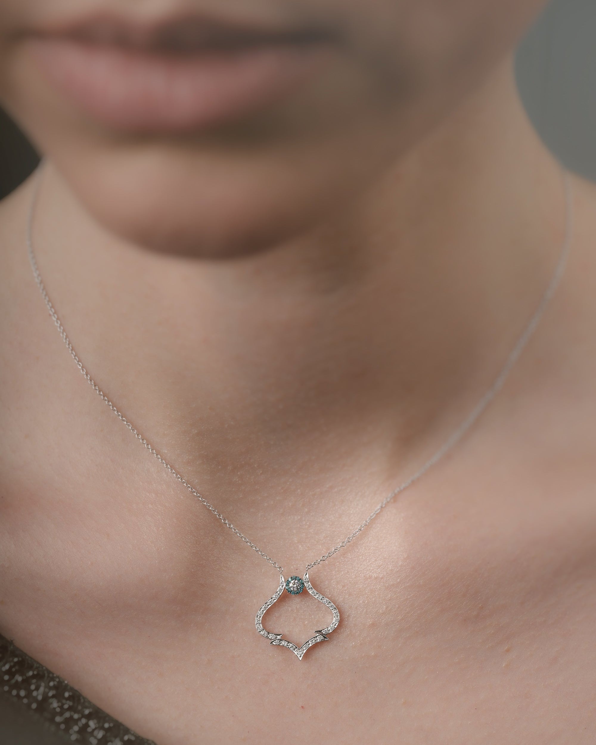 Necklace with a pendant worn by a person, focusing on the jewelry.