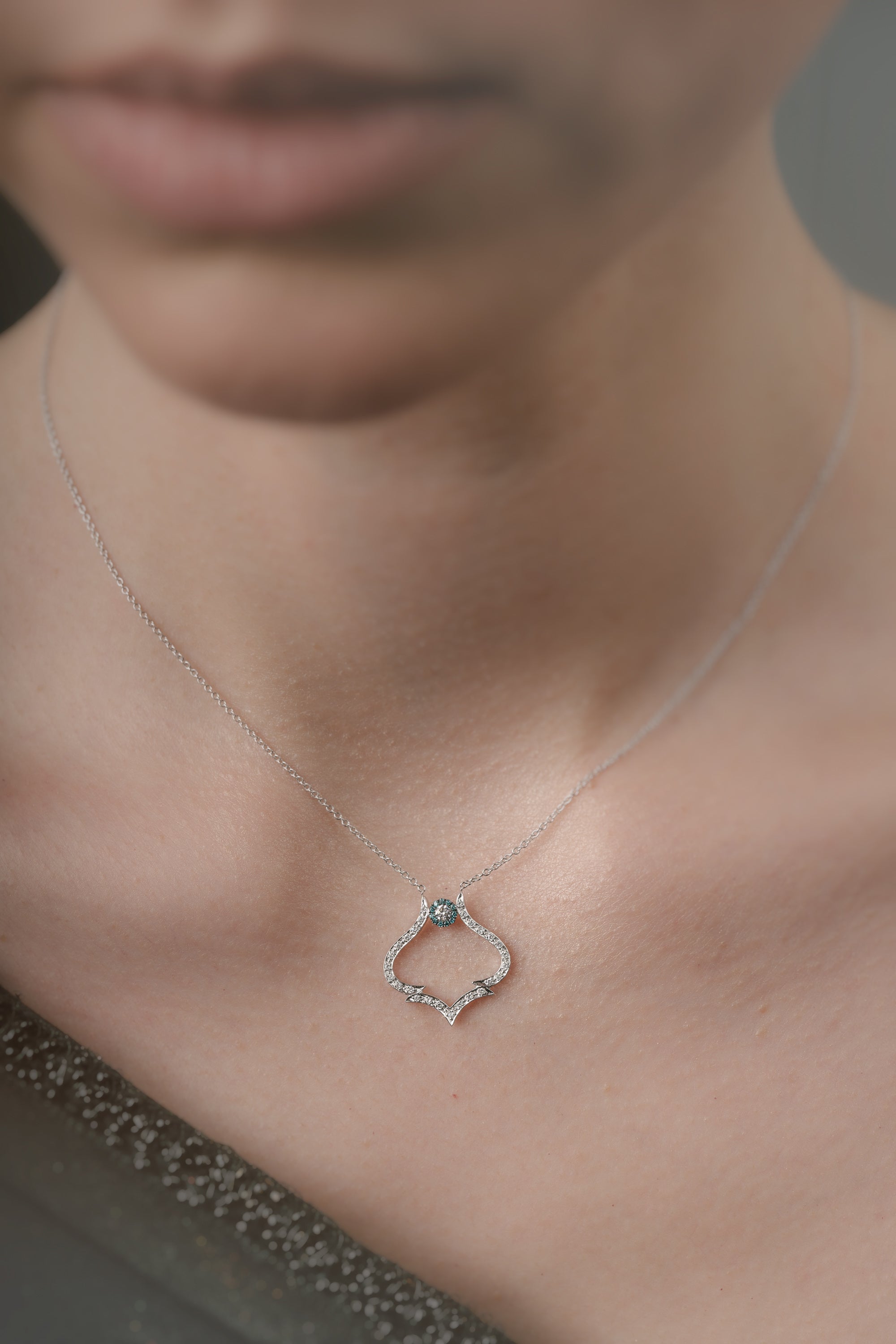 Necklace with a pendant worn by a person, focusing on the jewelry.