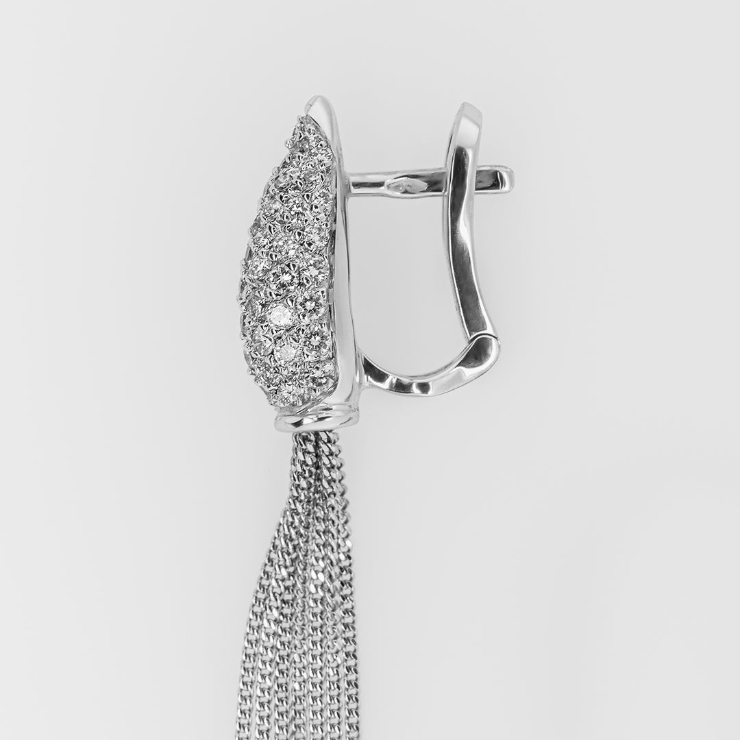 White gold earring with a chain tassel on a light gray background