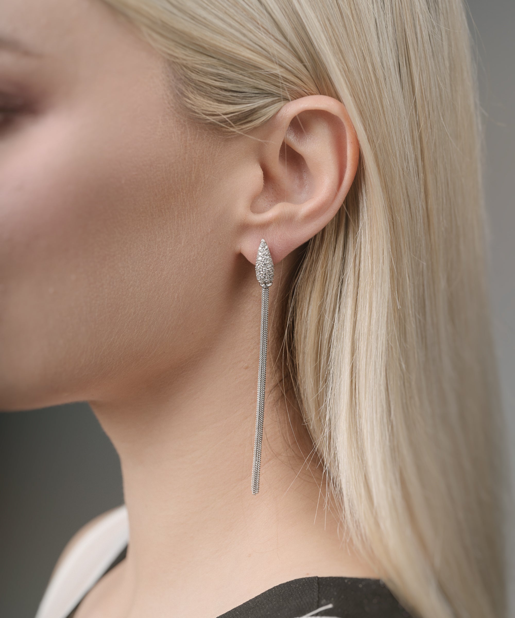 Close-up of a woman wearing a white gold earring with a blurred background