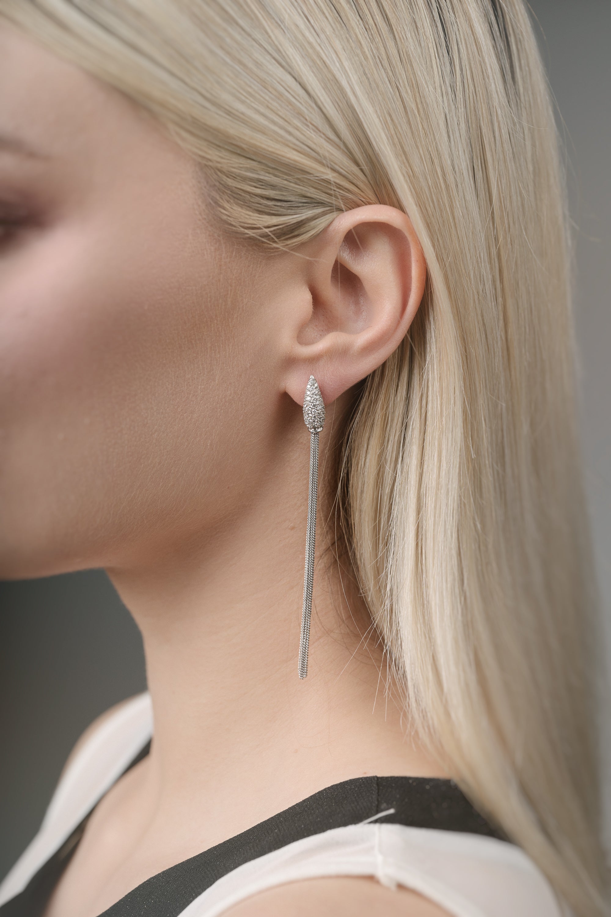 Close-up of a woman wearing a white gold earring with a blurred background