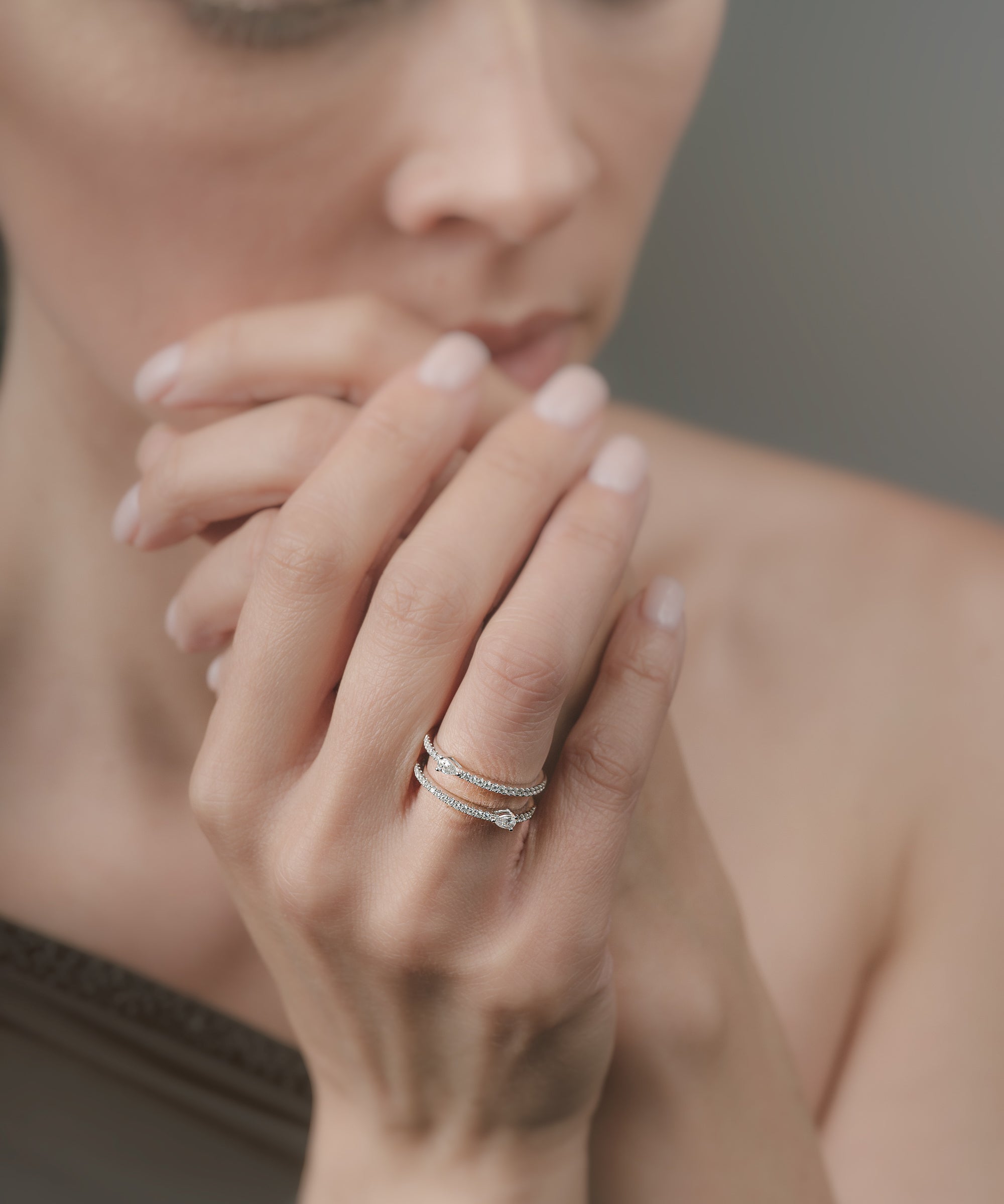 Close-up of a woman's hand with a double-ring on her fingers, blurred background