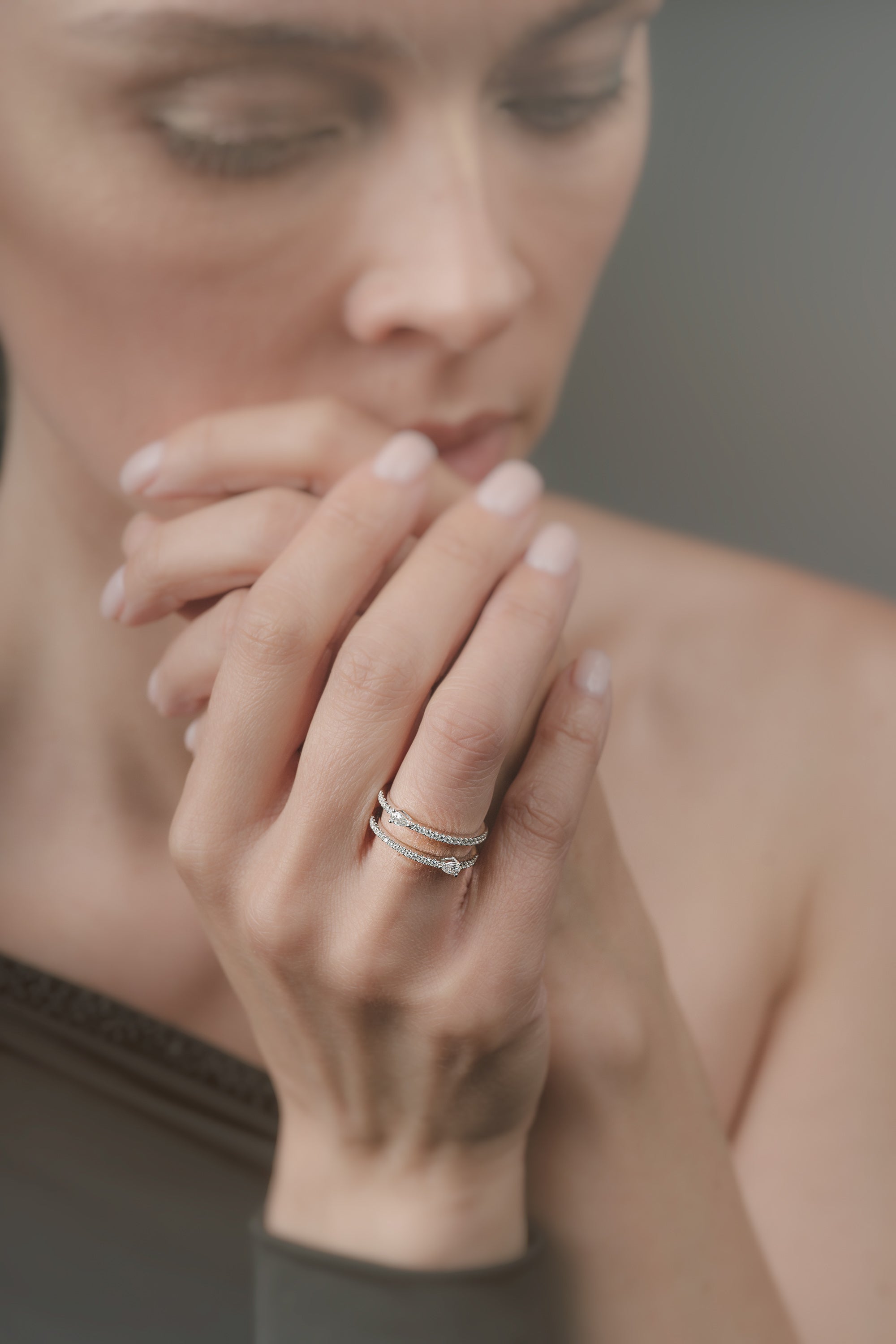 Close-up of a woman's hand with a double-ring on her fingers, blurred background