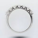 White gold ring with a half diamond band on a light gray background