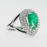 White gold ring with an emerald gemstone and diamond accents on a light gray background