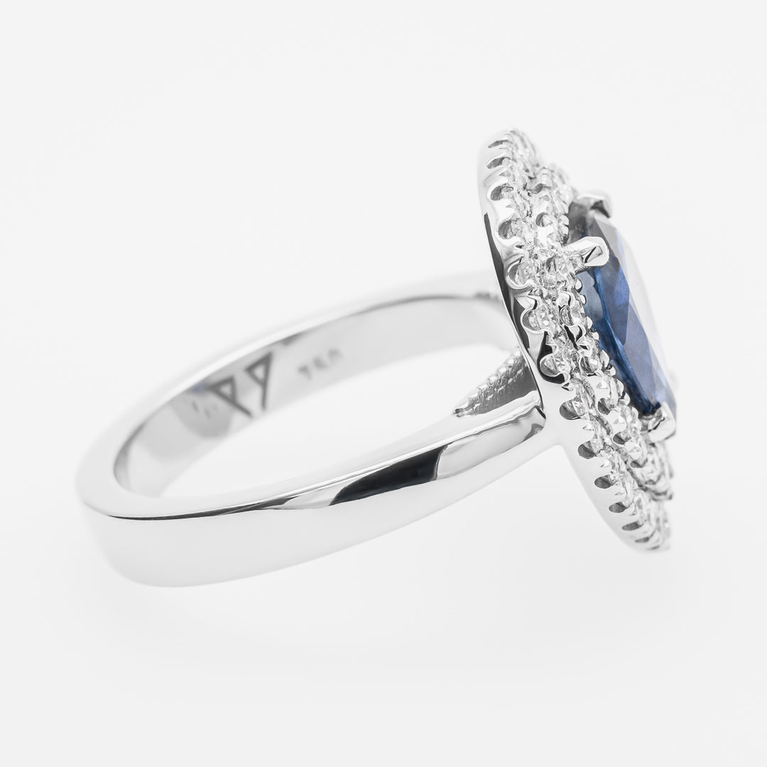 White gold ring with a sapphire gemstone and diamond accents on a white background
