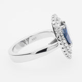 White gold ring with a sapphire gemstone and diamond accents on a white background