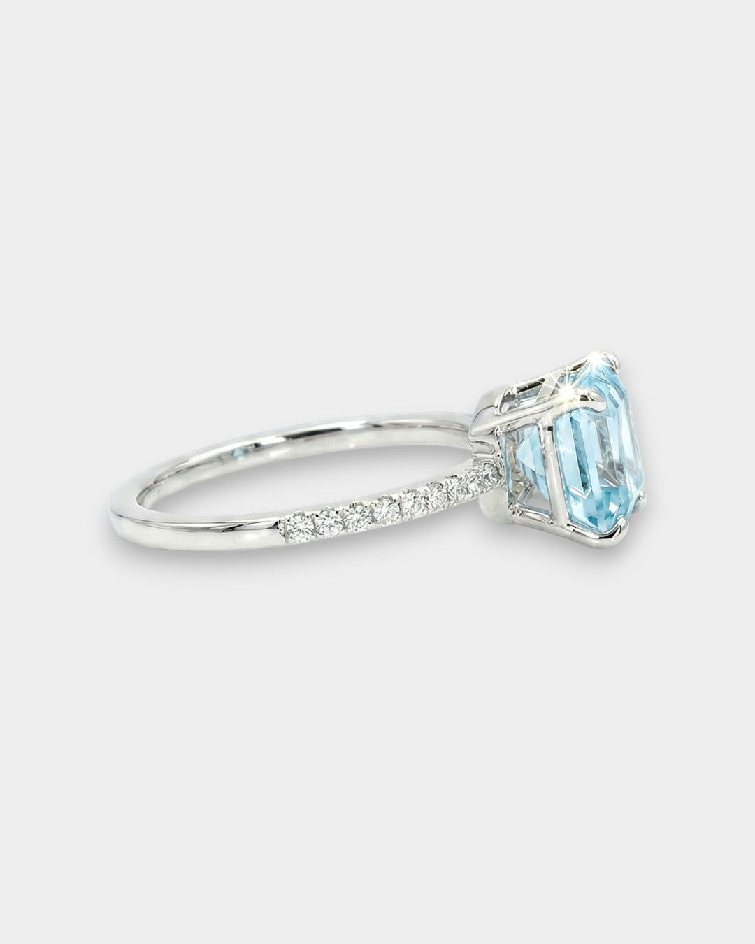 White gold ring with an aquamarine and diamond pave on a white background