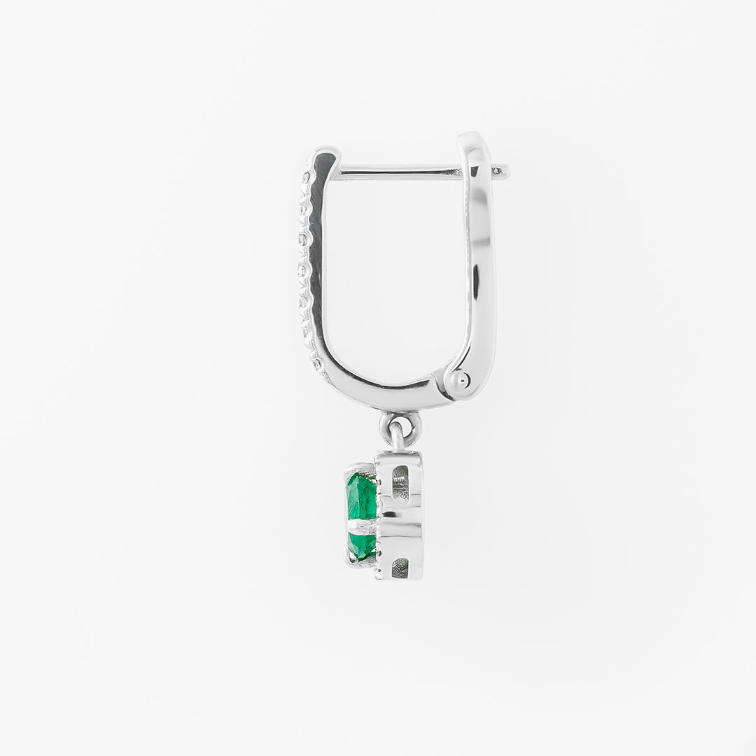 Silver hoop earring with a green emerald gemstone on a white background