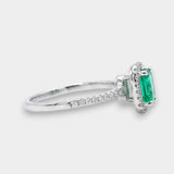 Ring with a green emerald and diamond accents on a white background