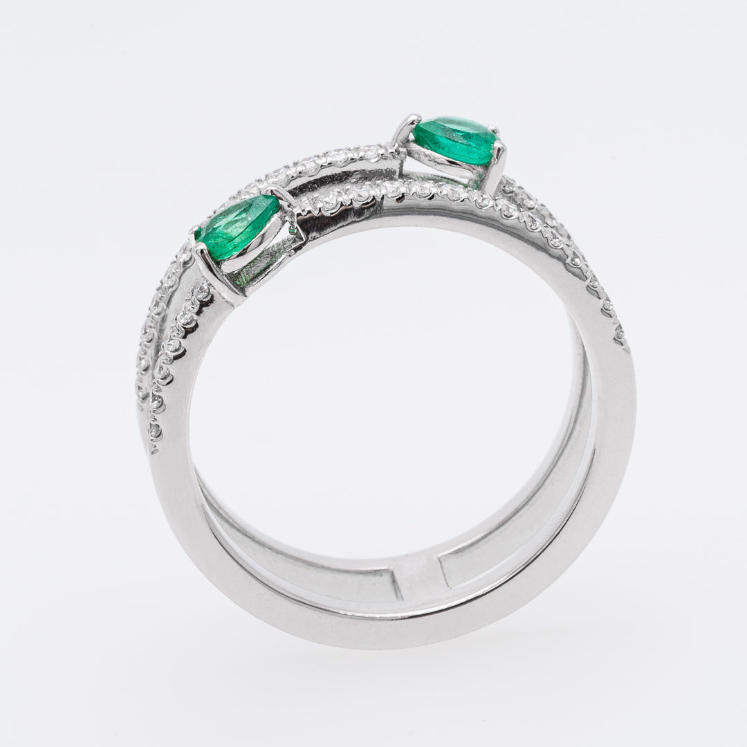 White gold ring with emerald stones on a white background