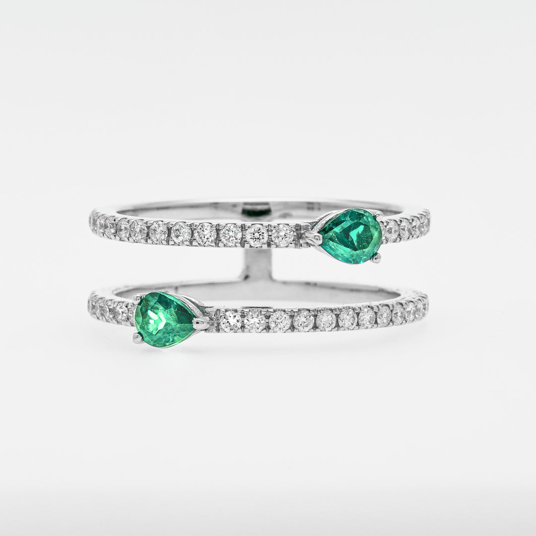 Double band rings with green emeralds and diamonds on a white background