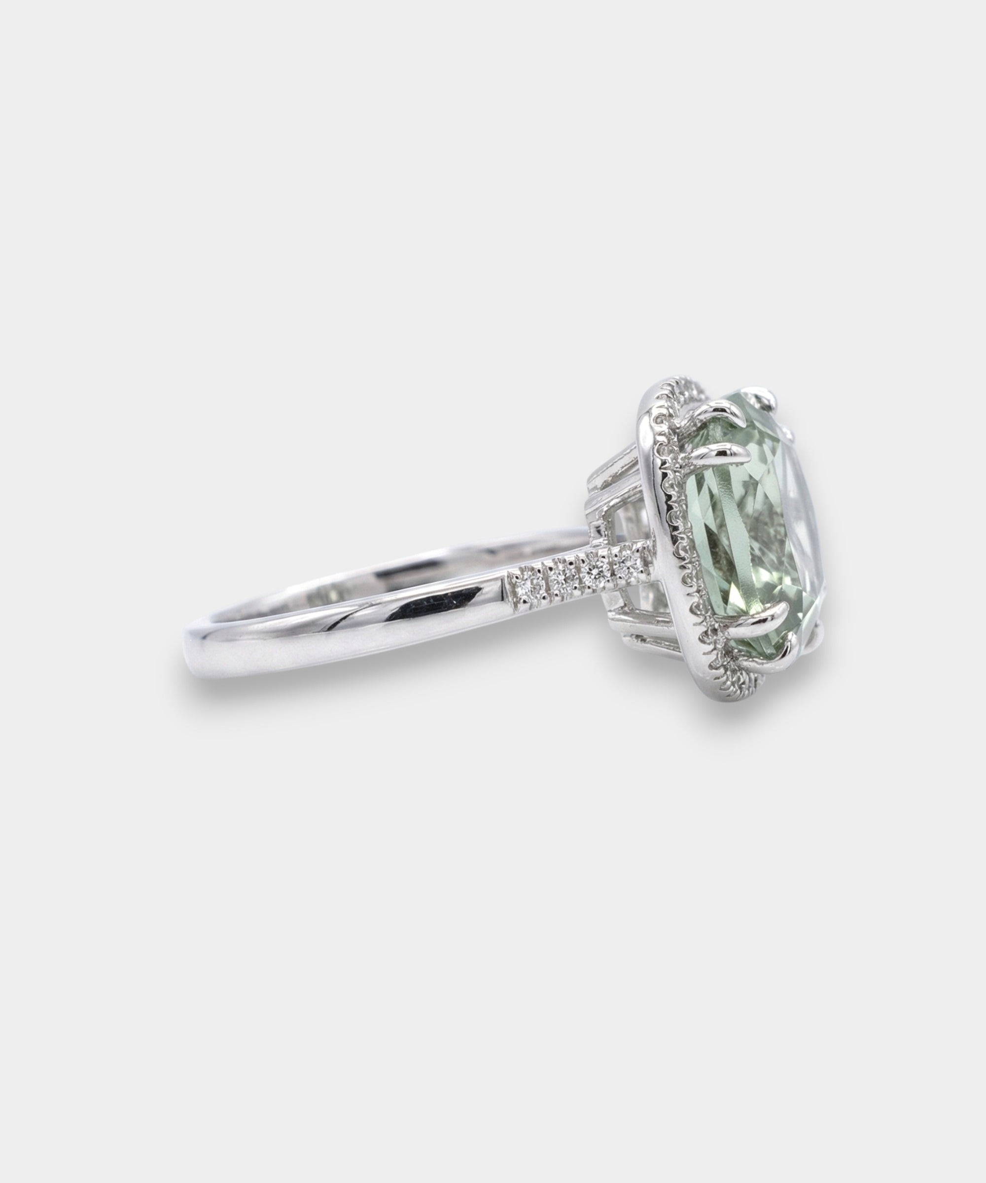 Green amethyst gemstone ring with diamond accents on a white background