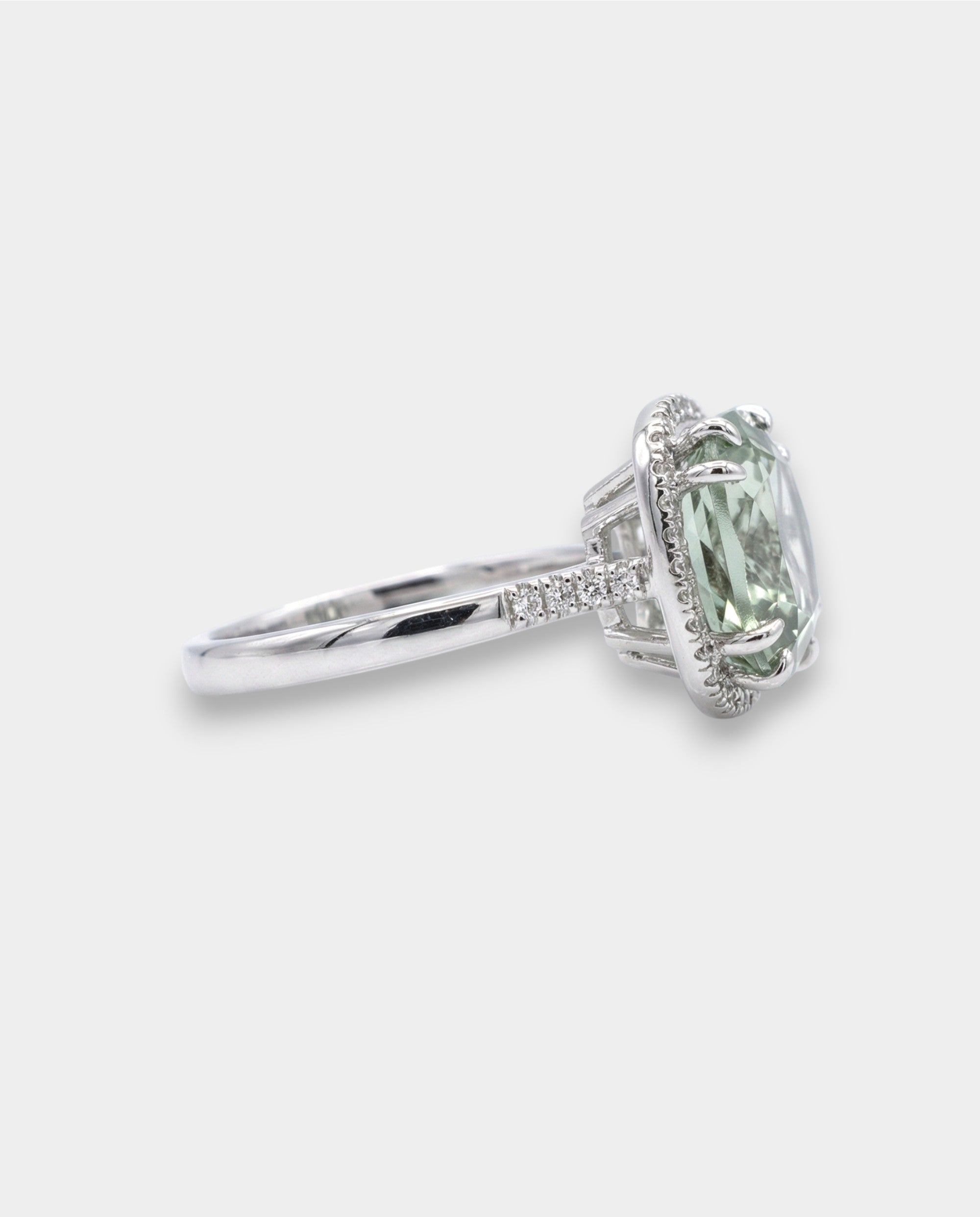Green amethyst gemstone ring with diamond accents on a white background