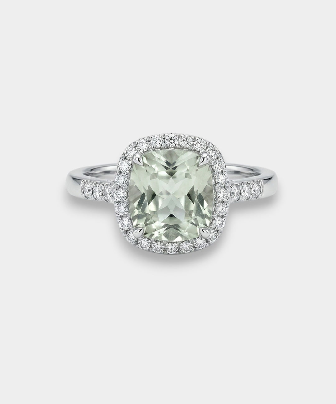 Ring with a green amethyst gemstone and diamond halo on a light gray background