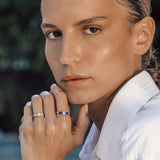 Woman wearing two rings with a blurred natural background