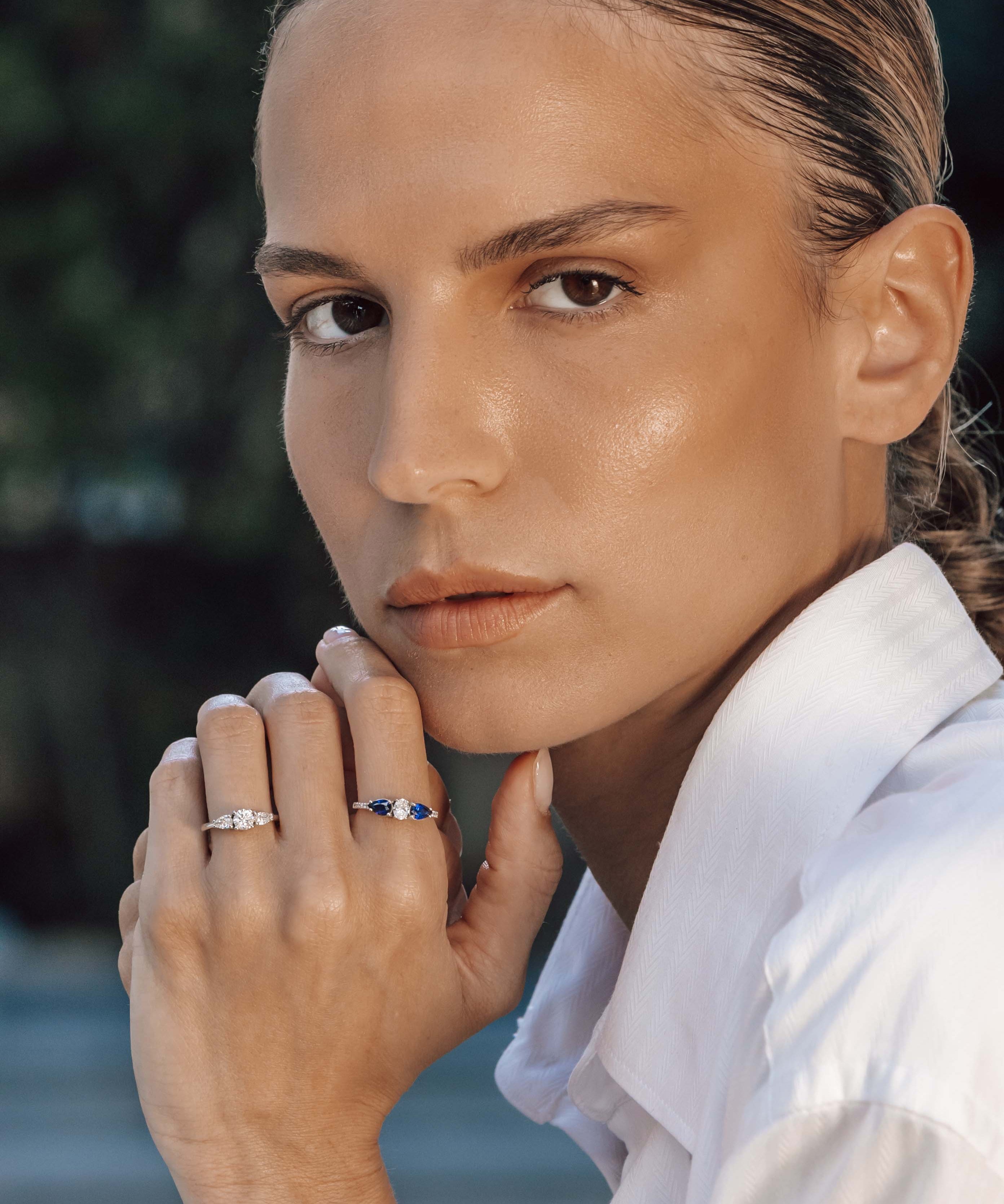 Woman wearing two rings with a blurred natural background
