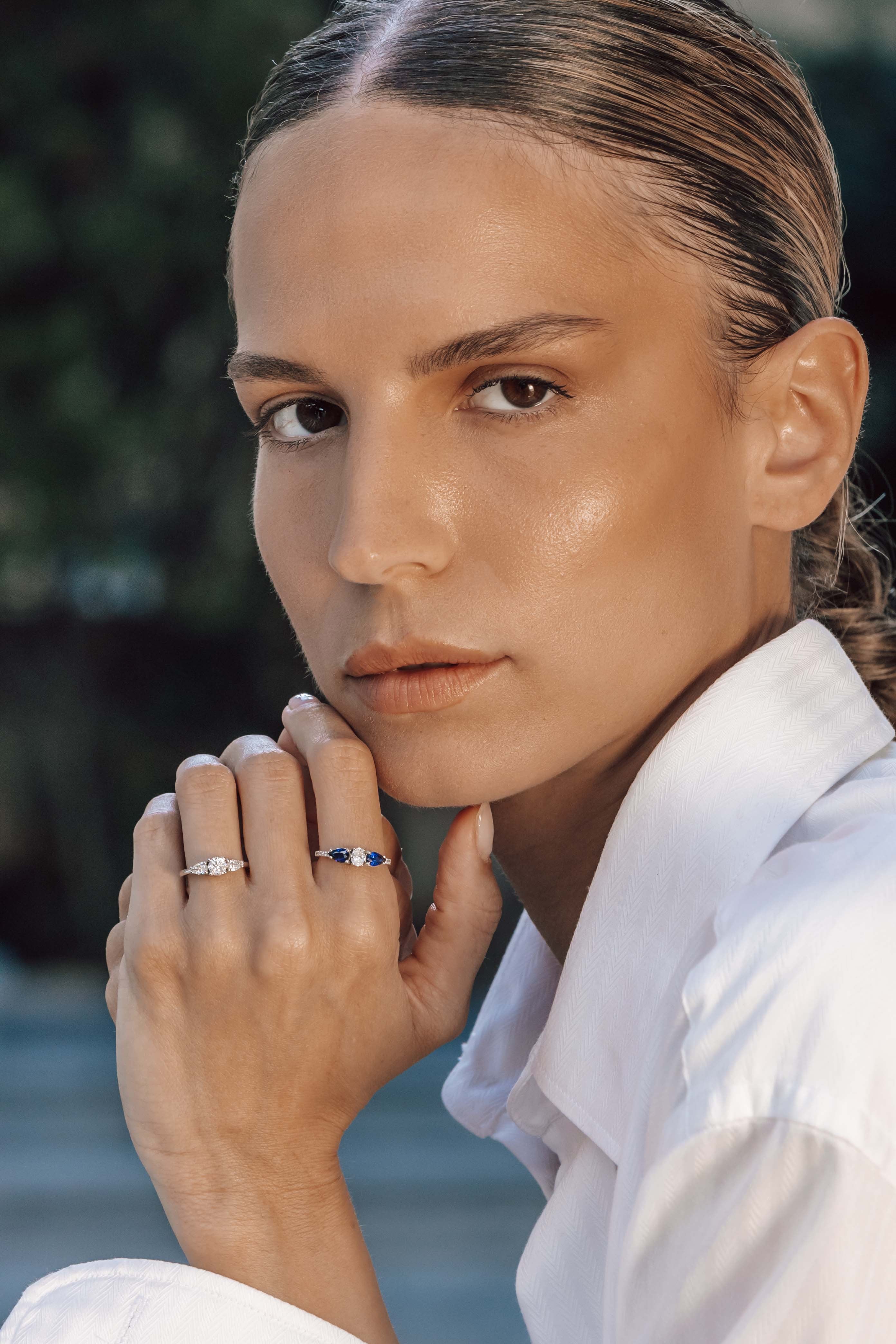 Woman wearing two rings with a blurred natural background