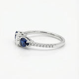 White gold ring with a diamond and blue sapphires on a white background