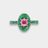 Ring with pink gemstone and green gemstones on a white background