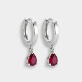 White gold hoop earrings with red rubies on a white background