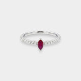 Ring with a red ruby gemstone and diamond accents on a white background